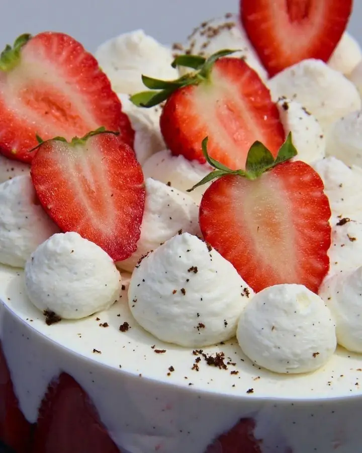 Son fraisier entier, fraises coupées et rosaces de chantilly sur le dessus