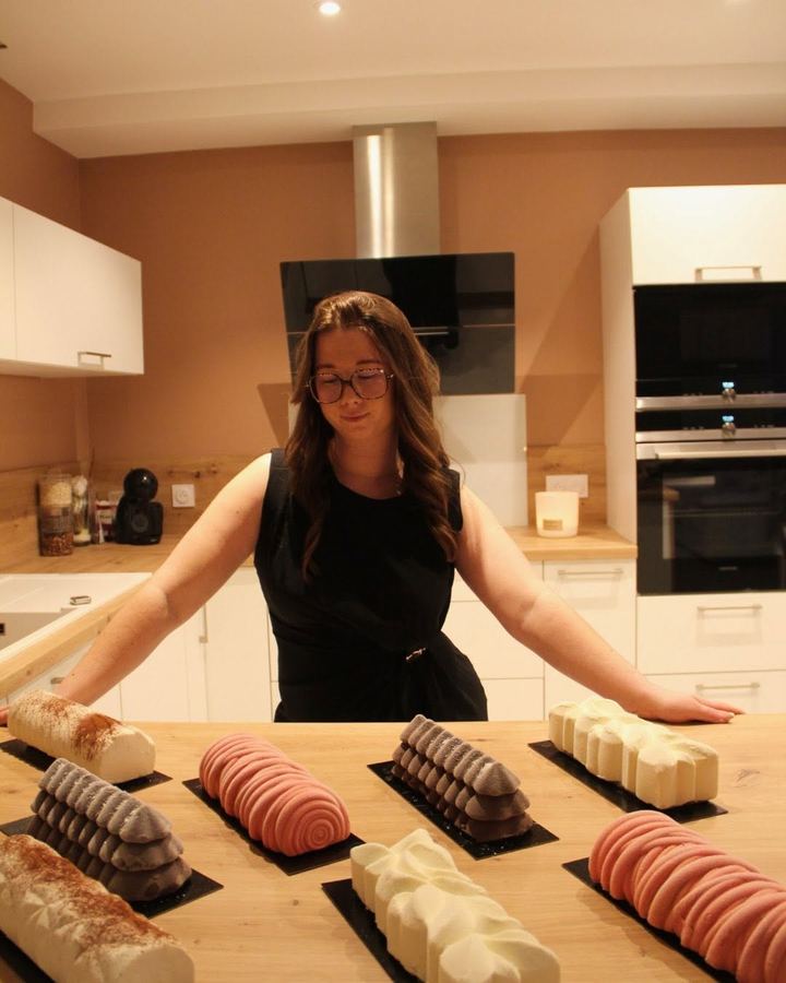 Océane derrière la table de ses bûches, dans sa cuisine
